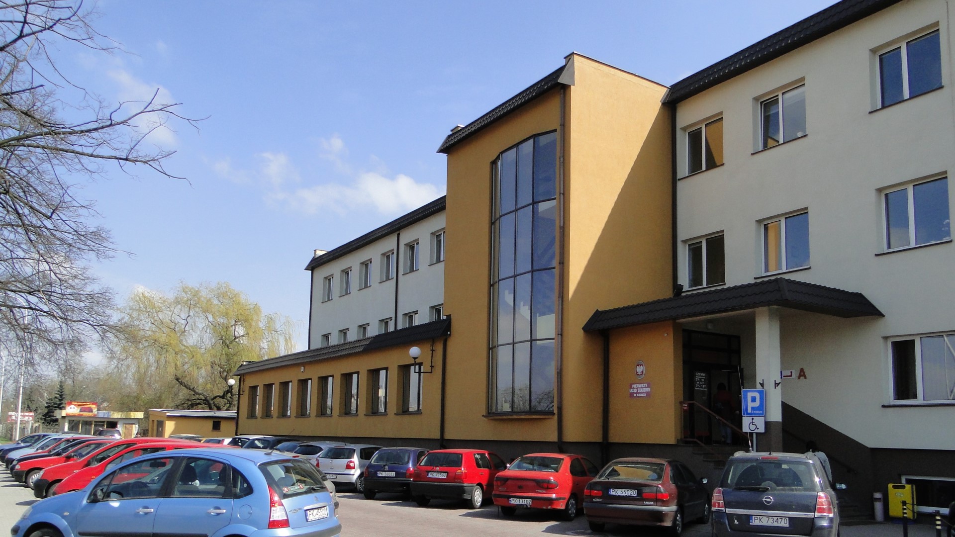 Na zdjęciu budynek w beżowo - miodowej elewacji