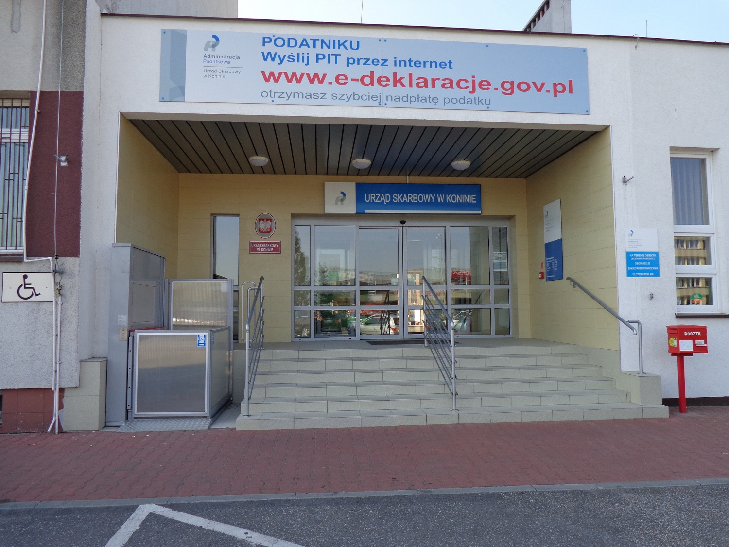 Na zdjęciu budynek w szaro - wiśniowej elewacji