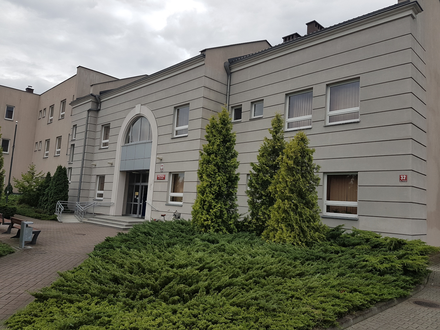 Na zdjęciu budynek w popielato-beżowej elewacji