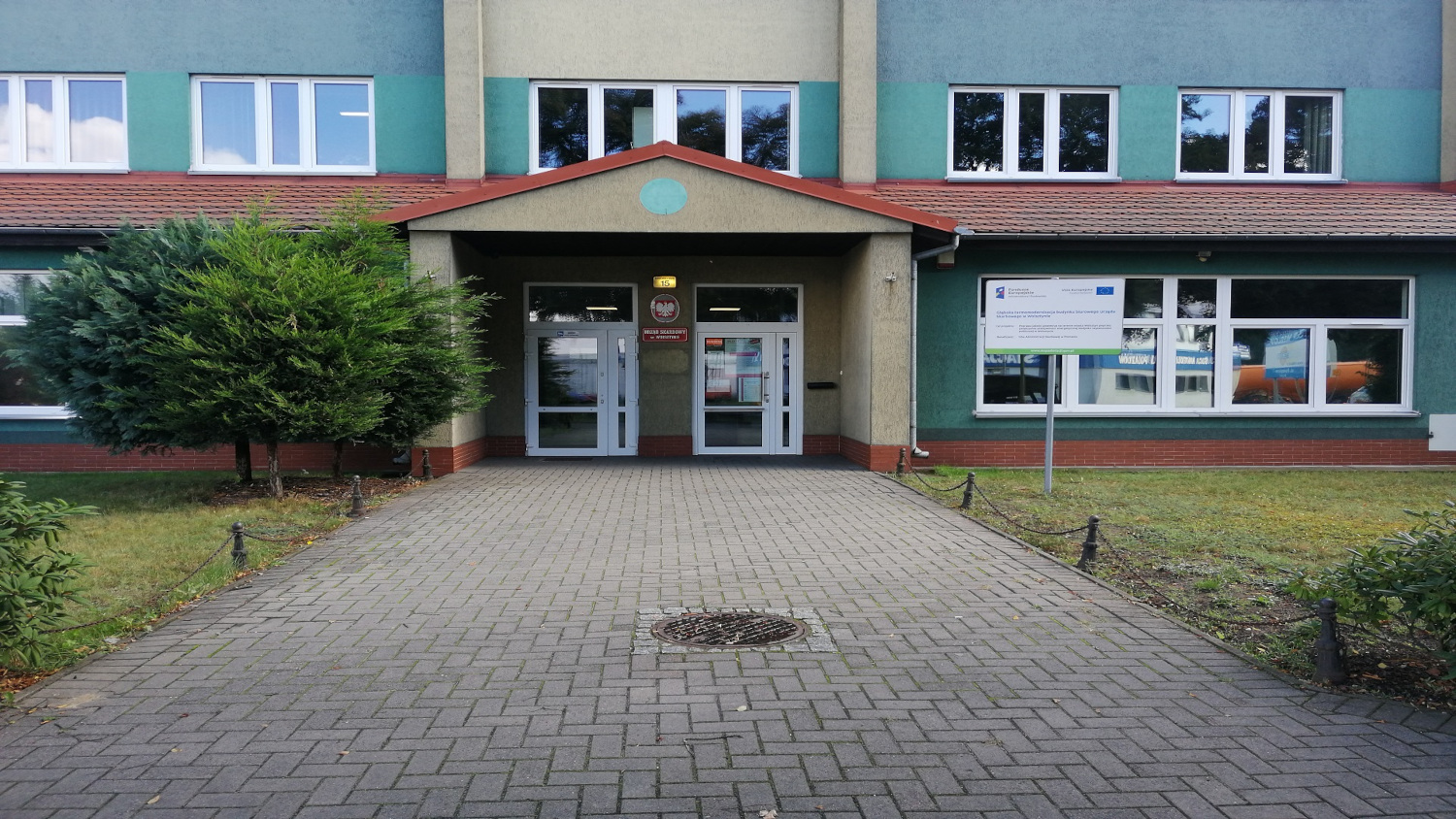 Na zdjęciu budynek elewacja w kolorze jasnym i niebieskim