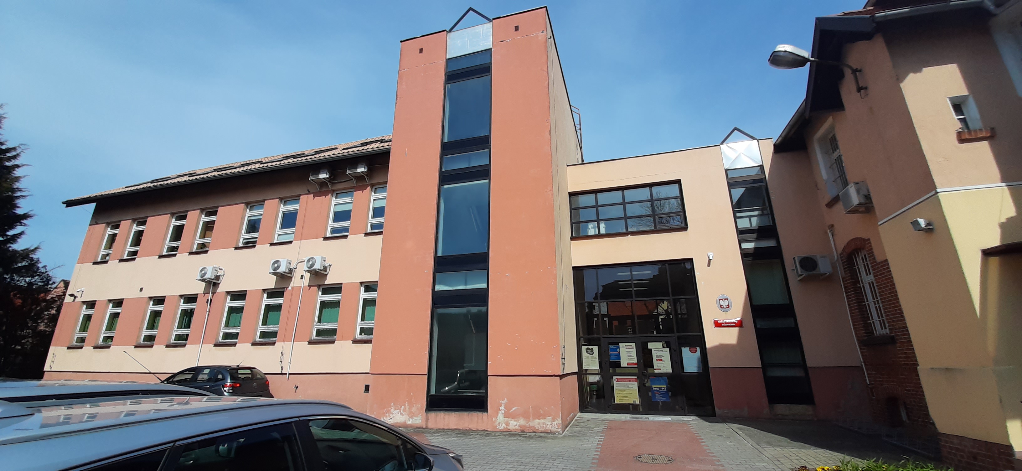 Na zdjęciu budynek w ceglasto-beżowej elewacji