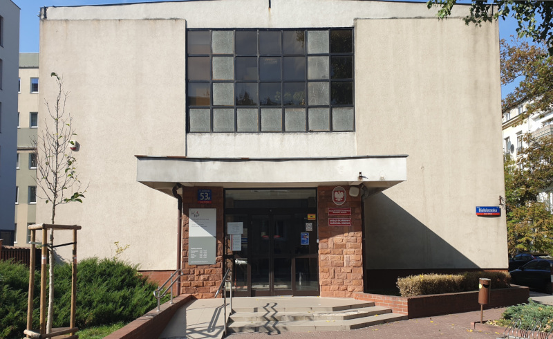 Budynek Urzędu Skarbowego Warszawa-Bemowo. Przed budynkiem małe drzewko.