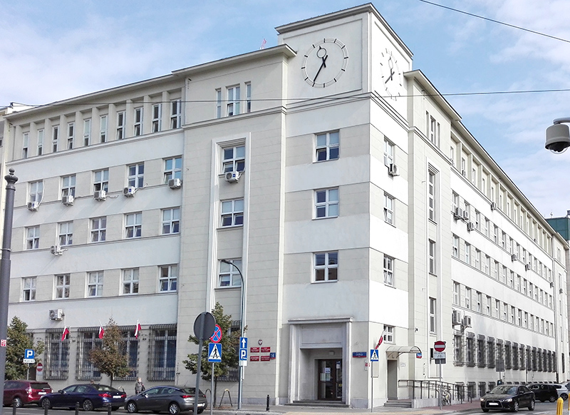 Budynek Pierwszego Urzędu Skarbowego Warszawa-Śródmieście. Przed budynkiem parking, a na nim kilka samochodów