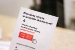 Broszura informacyjna na której znajduje się tekst: Planujesz wizytę w urzędzie skarbowym. Umów dogodny termin przez stronę podatki.gov.pl.