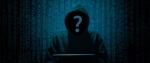Postać w kapturze siedząca przed komputerem. Zamiast twarzy znak zapytania.