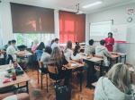 Uczniowie siedzący w ławkach w klasie słuchający z uwagą prowadzącego szkolenie podatkowe w Myślenicach.