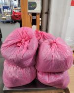 Różowe worki stoją na wadze.