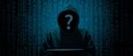 Zakapturzona osoba przy komputerze, zamiast twarzy ma znak zapytania.