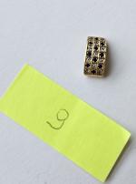 9 - zdjęcie przedstawia wisiorek złoty z imitacjami diamentów i szafirów, próba złota 0,585, masa 3,85g;