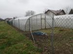 Działka będąca przedmiotem licytacji, widoczne ogrodzenie, powierzchnie szklarniowe z folii 