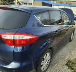 Samochód osobowy ford C-MAX koloru granatowego. Przyciemnione szyby. Samochód pokolizyjny. Uszkodzony przód samochodu. 