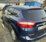 Samochód osobowy ford C-MAX koloru granatowego. Przyciemnione szyby. Samochód pokolizyjny. Uszkodzony przód samochodu. 