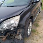 Samochód osobowy Honda CR-V koloru czarnego. Po kolizyjny, uszkodzony przód i bok samochodu. 