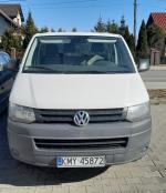 Samochód osobowy VW Transporter koloru białego, oszklony, dwa rzędy siedzeń. 