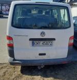 Samochód osobowy VW Transporter koloru białego, oszklony, dwa rzędy siedzeń. 