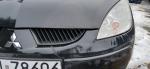 Samochód osobowy Mitsubishi Colt koloru czarnego. Trzydrzwiowy. Lekko zarysowany przedni zderzak.  