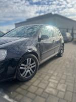 Samochód osobowy VW Golf  w kolorze czarnym, pięciodrzwiowy. Lekko wgniecione przednie nadkole. 
