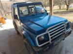 Samochód osobowy Suzuki Samurai koloru niebieskiego, wyeksploatowany. 