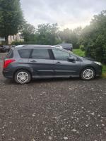  Samochód osobowy Peugeot 308 kombi, w kolorze grafitowym, rok produkcji 2008, przebieg 262 tysięcy km, z wyraźnymi wgnieceniami, otarciami i śladami wyeksploatowania wewnątrz.