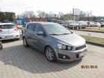 Chevrolet Aveo  pojemność silnika 1248,00 cm³, rok produkcji 2012. Zdjęcie przedstawia prawy bok i przód szarego samochodu