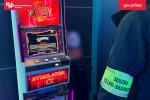 Funkcjonariusz Służby Celno-Skarbowej stoi przed automatem do nielegalnych gier hazardowych