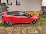 Samochód osobowy Ford Fiesta w kolorze czerwonym. Bok pojazdu