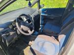 Samochód osobowy Mazda Premacy, kombi w kolorze srebrnym, rok produkcji 2004, wgniecenia w karoserii na nadkolu, tapicerka foteli materiałowa, wyeksploatowane wnętrze z widocznymi przetarciami na kierownicy i fotelu kierowcy.