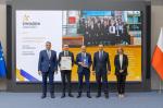 Grafika dekoracyjna, Andrzej Domański, minister finansów i gospodarki, Marcin Łoboda, szef Krajowej Administracji Skarbowej, oraz przedstawiciele Urzędu Skarbowego w Staszowie prezentują dyplom i statuetkę „Gwiazda Jakości