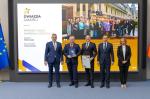 Grafika dekoracyjna, Andrzej Domański, minister finansów i gospodarki, Marcin Łoboda, szef Krajowej Administracji Skarbowej, oraz przedstawiciele Urzędu Skarbowego w Staszowie prezentują dyplom i statuetkę „Gwiazda Jakości