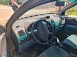 Samochód osobowy Mitsubishi, Space Star, hatchback w kolorze złotym, rok produkcji 1999, tapicerka foteli materiałowa, wyeksploatowane wnętrze z widocznymi licznymi plamami na fotelu kierowcy.