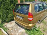 Samochód osobowy Mitsubishi, Space Star, hatchback w kolorze złotym, rok produkcji 1999, tapicerka foteli materiałowa, wyeksploatowane wnętrze z widocznymi licznymi plamami na fotelu kierowcy.