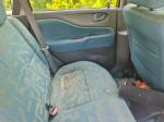 Samochód osobowy Mitsubishi, Space Star, hatchback w kolorze złotym, rok produkcji 1999, tapicerka foteli materiałowa, wyeksploatowane wnętrze z widocznymi licznymi plamami na fotelu kierowcy.