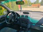 Samochód osobowy Mitsubishi, Space Star, hatchback w kolorze złotym, rok produkcji 1999, tapicerka foteli materiałowa, wyeksploatowane wnętrze z widocznymi licznymi plamami na fotelu kierowcy.