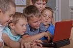 Grupka dzieci przy komputerze.